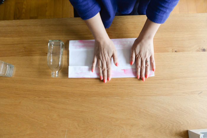 2.色のついた半紙を下面にし、ガラス瓶の高さに合わせて上下を折る。