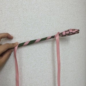 リボンの長い方を茎に斜めに巻きつけていきます。