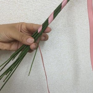 ある程度巻いたら、茎の真ん中に一度リボンを通し、折り返します。