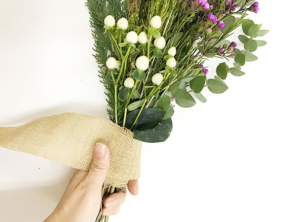 ③まとめます  植物を束ねたら、麻紐でしっかりとぎゅっとまとめます。まとめた上から好みのリボンなどで飾ります。今回は麻のテープを巻いてラフィアテープで結んで飾りました。