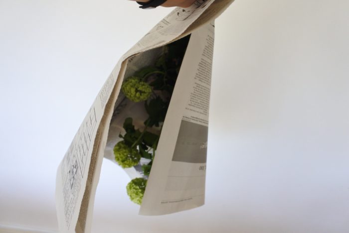 逆さにして花や葉が潰れないように気をつけながら新聞紙を巻いていきます。