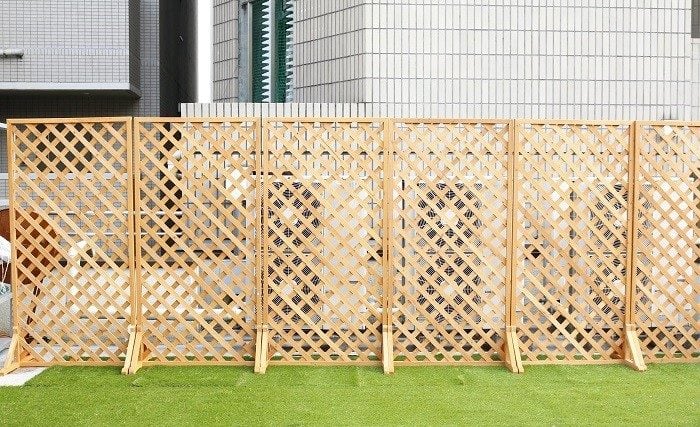 木製の板が格子状になっているラティスフェンスは、目隠し度は低いですが、風通しが良く圧迫感が少ないことが特長です。光や風を通すので、つる性の植物をはわせても良く育ちます。  植物をはわせることで目隠し度もアップ。開放感たっぷりな中で、適度な目隠しができるフェンスです。