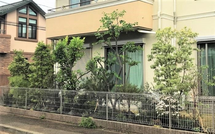 写真のお庭周りに境界線として設置されているフェンスがメッシュフェンスです。メッシュフェンスは仕切りの役目として設置されることが多く、そのままでは目隠しとしての機能はゼロ。  しかし、メッシュフェンスにつる性の常緑植物をはわせたり植物と合わせるとフェンスに目隠し機能がプラスされます。